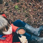 Image of little boy sat down drinking soup