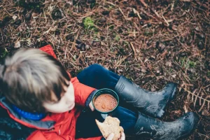 Image of little boy sat down drinking soup