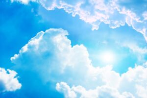 Image of sunshine in a blue sky with a few white clouds to illustrate post