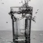 Image of glass of water on table being splashed on to surface of table to illustrate post