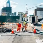 Image of construction personnel working on the road to illustrate post