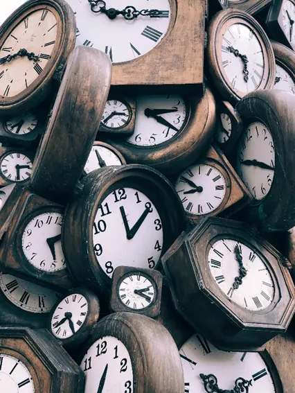 Image of a jumble of old clocks to illustrate post