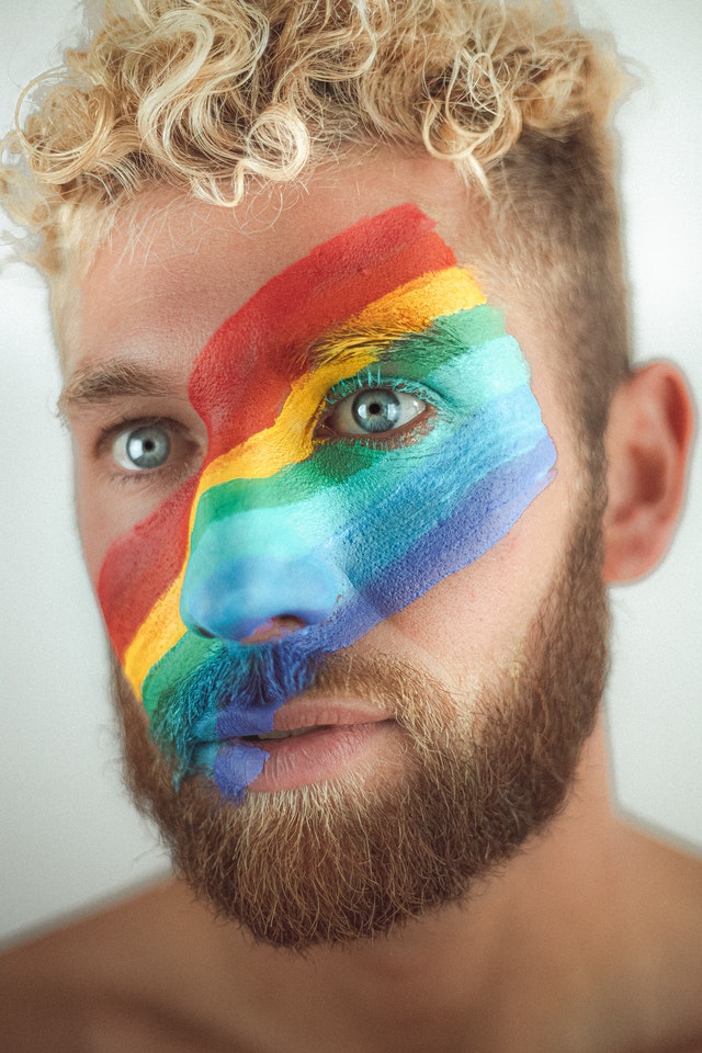 Image of a man with rainbow painted on face, used to illustrate post.