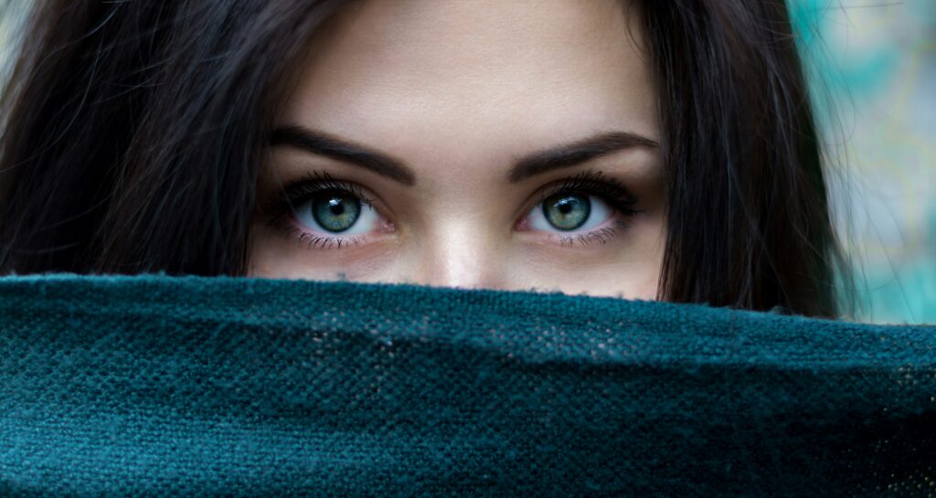 Image of woman looking intensely over a cover hiding the lower part of her face, used to illustrate post.